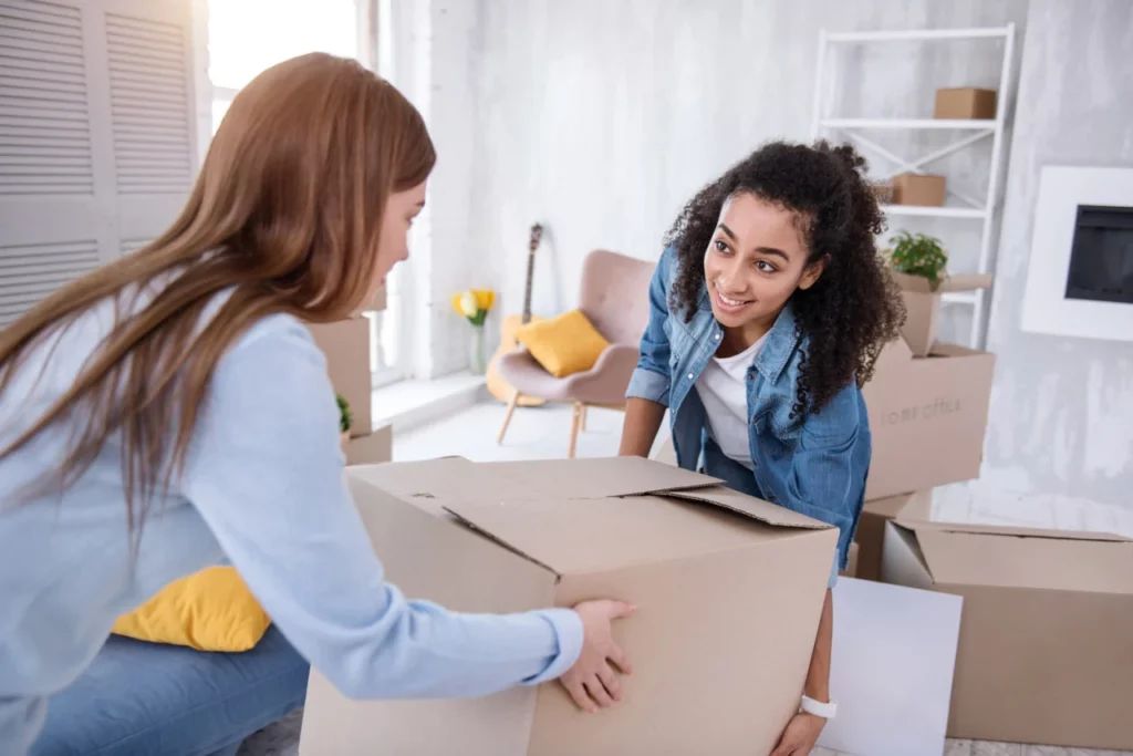 2 femmes portant un carton de déménagement