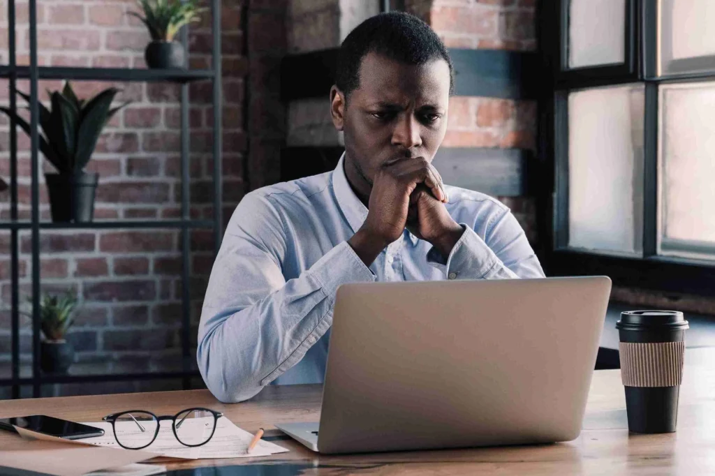 homme en reflexion devant ordinateur